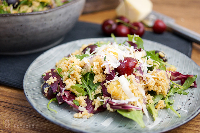 Mit Orangensaft versetztes Couscous mit Kirschen auf Rucola