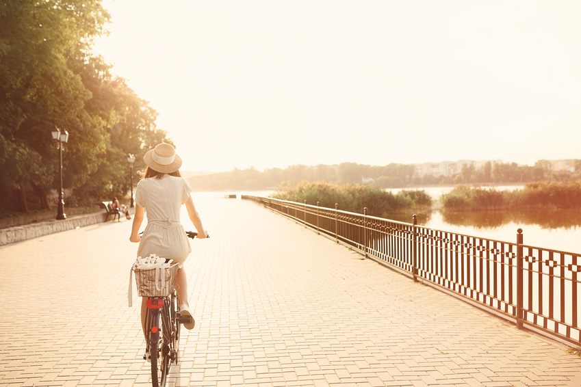 Detox Tipps, Frau auf Fahrrad an Flussufer