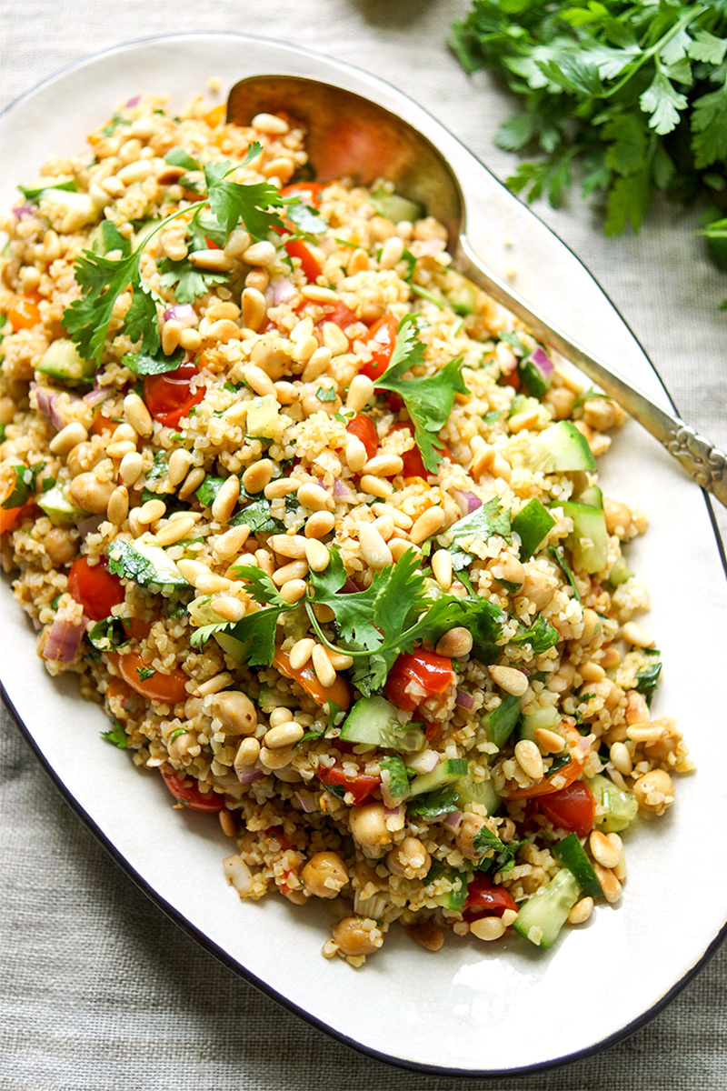 orientalischer Bulgur-Salat mit gerösteten Tomaten und Kichererbsen Rezept mit Sumach, Kreuzkümmel, Koriander, Gurke, Pinienkerne. Vegan, Vegetarisch
