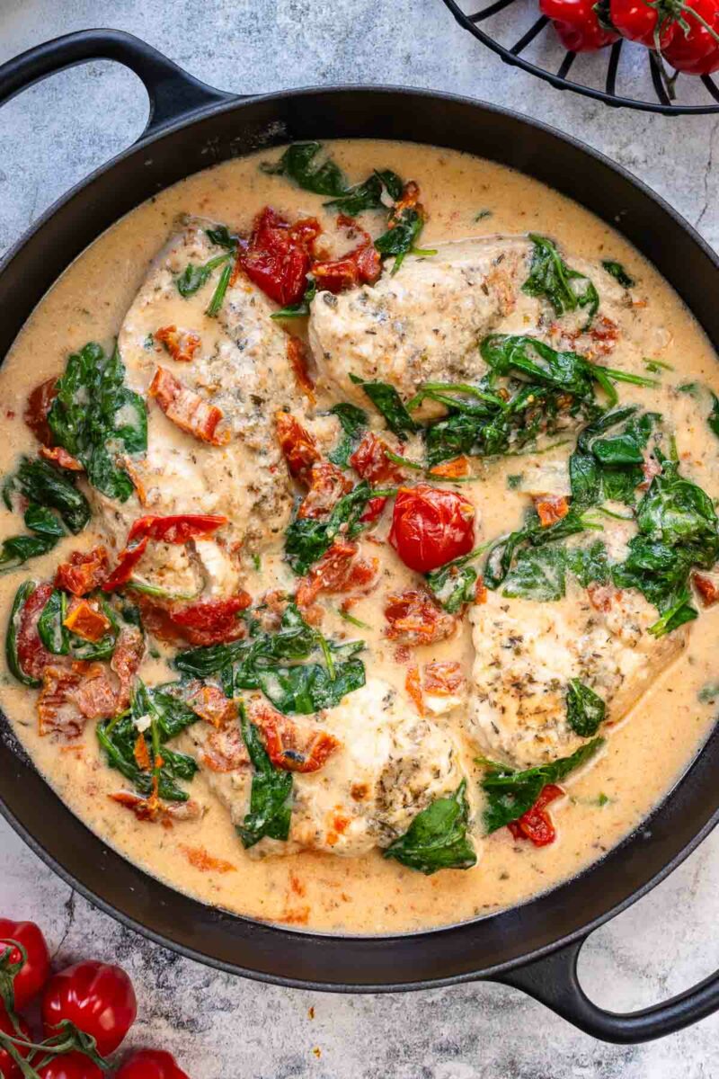 Hähnchenpfanne mit Kokos, Tomaten und Spinat in der Pfanne