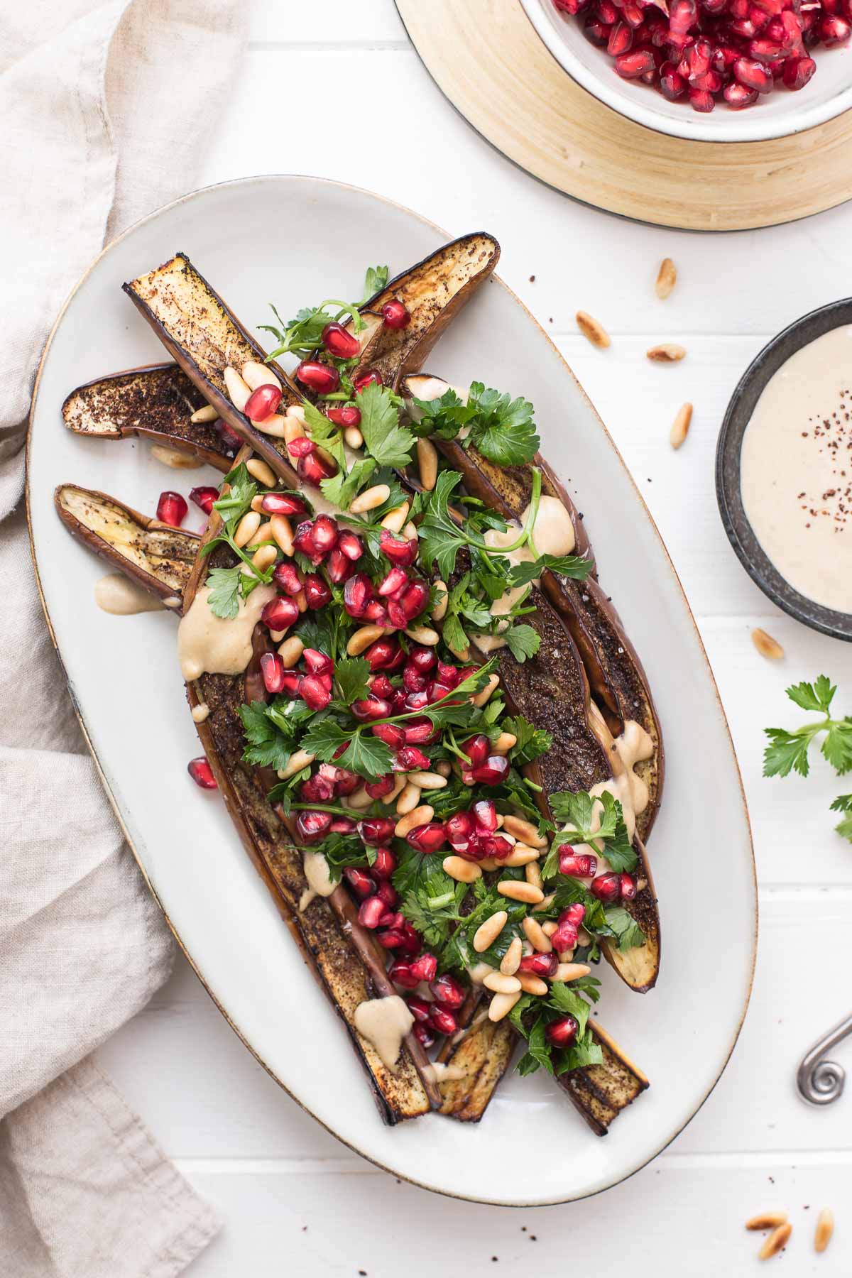 Geröstete japanische Aubergine mit Tahin-Soße, Granatapfel, Pinienkerne, Petersilie