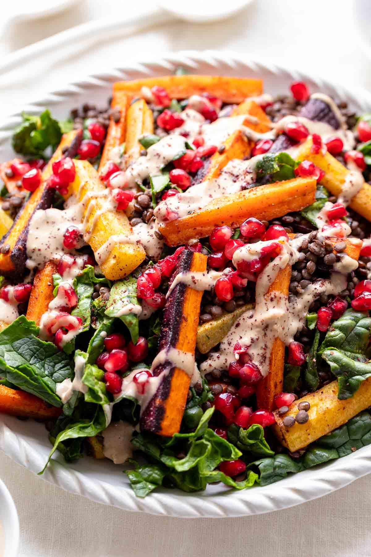 Linsensalat mit Karotten und Tahini-Dressing, garniert mit Granatapfelkernen