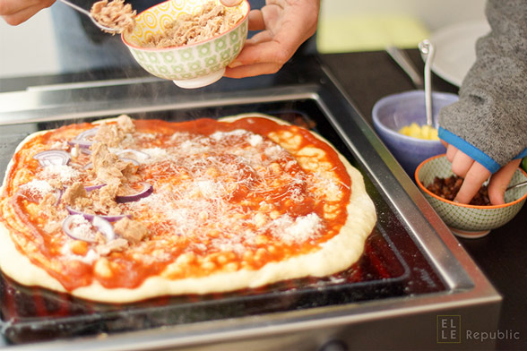 Grill-Pizza mit Thunfisch Topping belegen