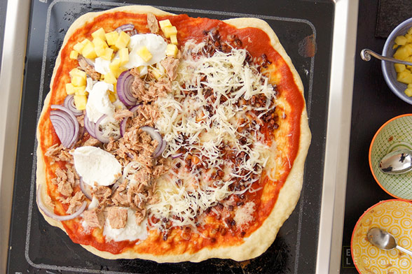 Fertige Grill-Pizza auf dem Tischgrill mit verschiedenen Toppings