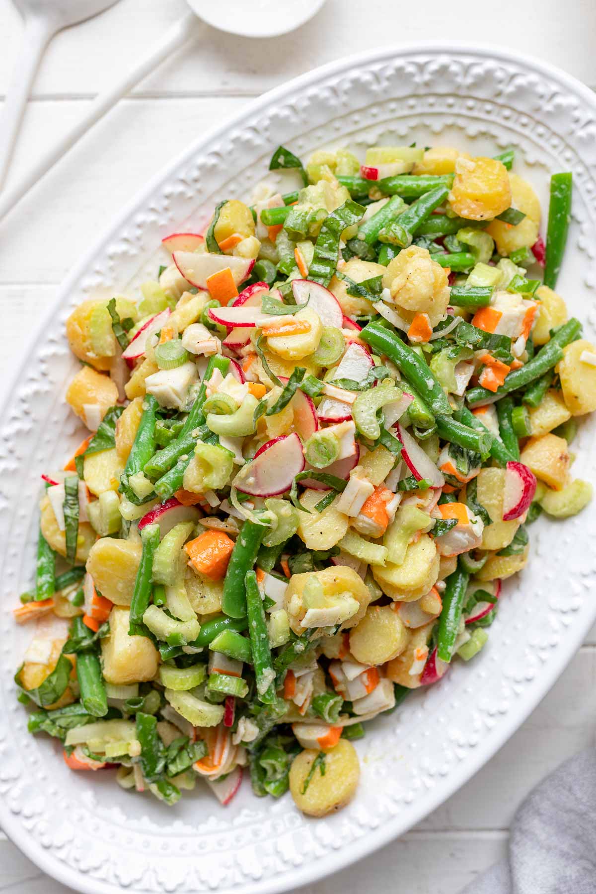 Einfacher Kartoffelsalat mit Surimi, grüne Bohnen, Sellerie und Radieschen in Öl Essig Dressing