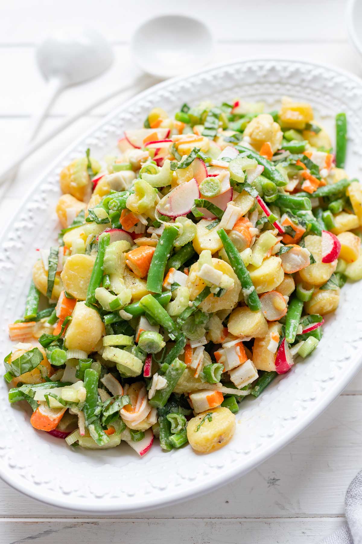 Einfacher Kartoffelsalat mit Surimi, grüne Bohnen, Sellerie und Radieschen in Öl Essig Dressing