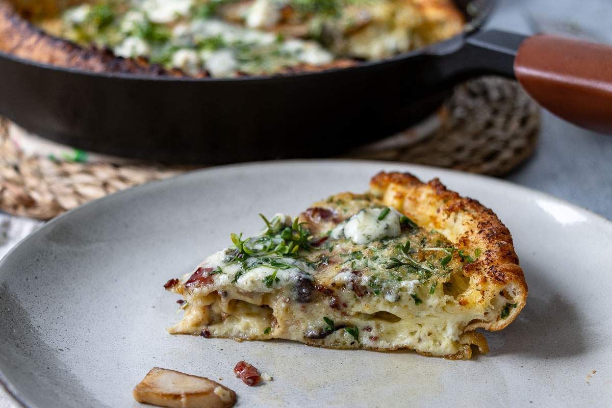 Herzhafte Ofenpfannkuchen Rezept (Dutch Baby) mit Speck, Roquerfort, Kräuterseitlinge auf ein Teller