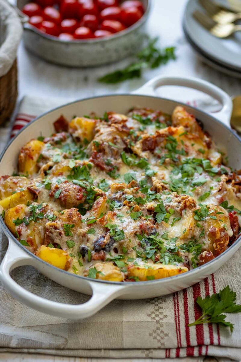 mediterraner Kartoffelauflauf mit jungen Kartoffeln, herzhaftem Parmaschinken, trockenen Tomaten, Kalamata Oliven und geschmolzenem Guyère-Käse.
