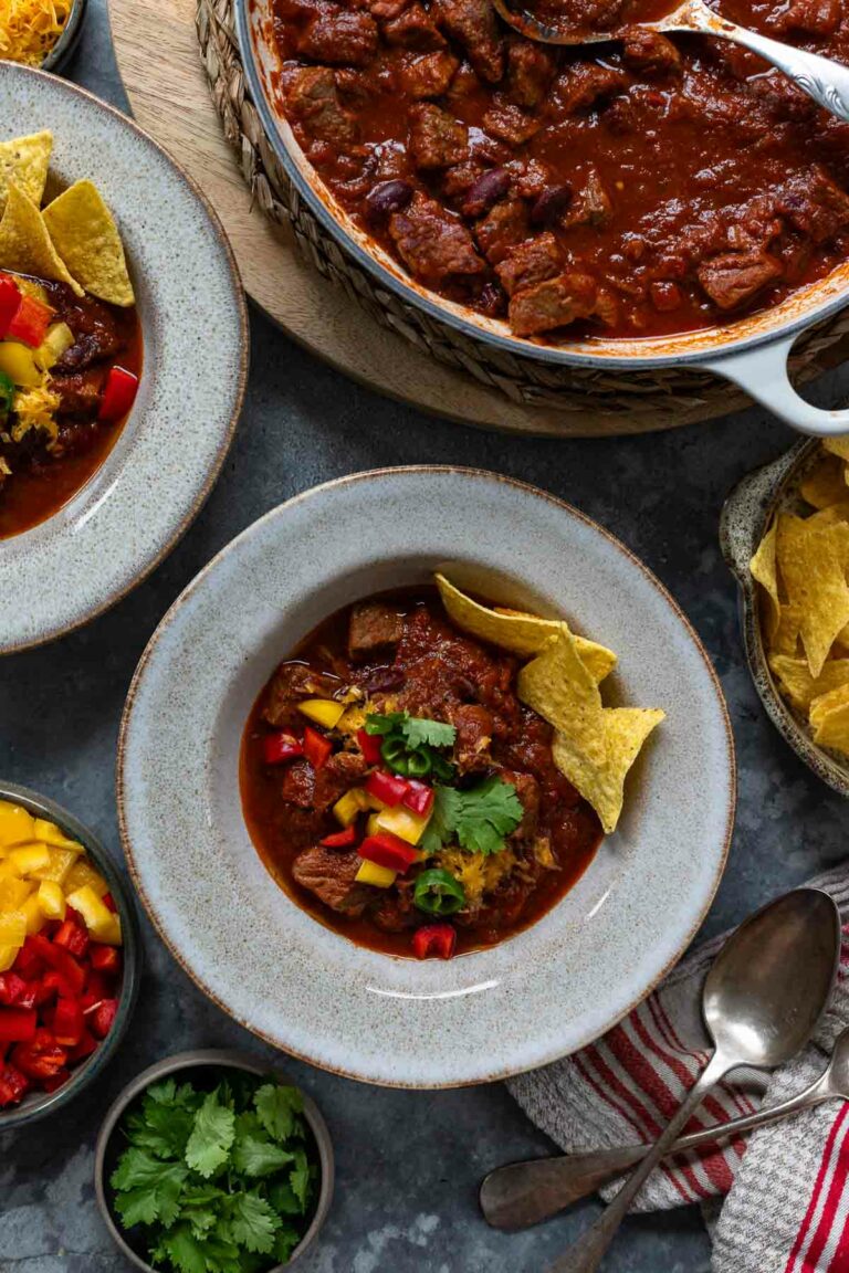 Chili con Carne mit Rindfleisch Rezept serviert mit Paprika, Cheddar-Käse und Tortilla Chips