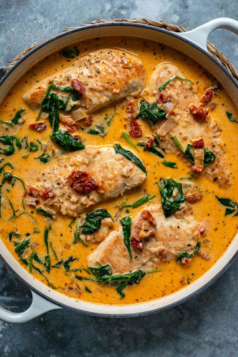 Nahaufnahme von Hähnchen in cremiger Parmesan-Sahnesoße mit getrockneten Tomaten und Spinat – ein einfaches und köstliches Rezept.