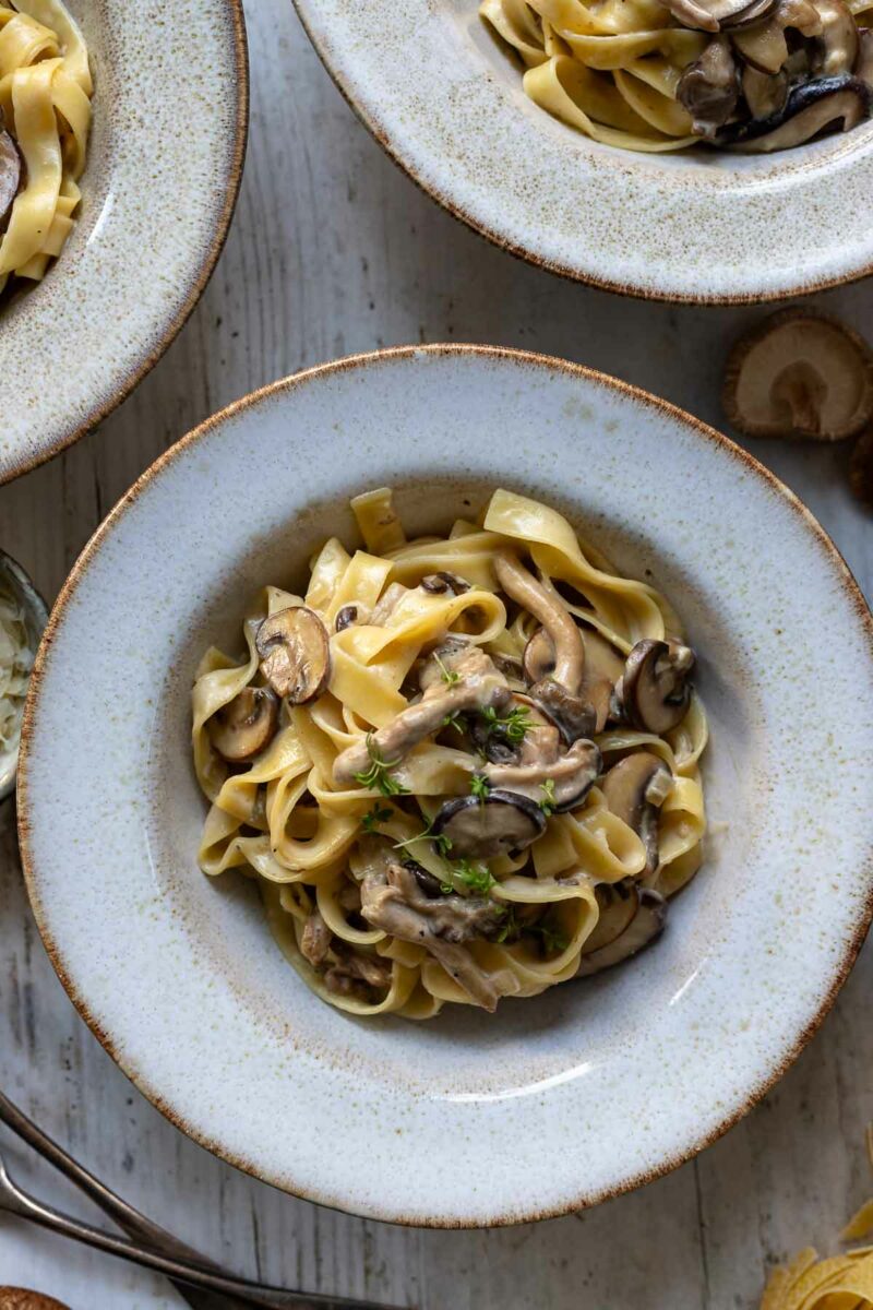 Nudeln mit Pilzen Rezept in Miso Rahmsoße, zubereitet mit Champignons, Austernpilze, Shiitake-Pilzen und Parmesan, garniert mit frischen Kräutern