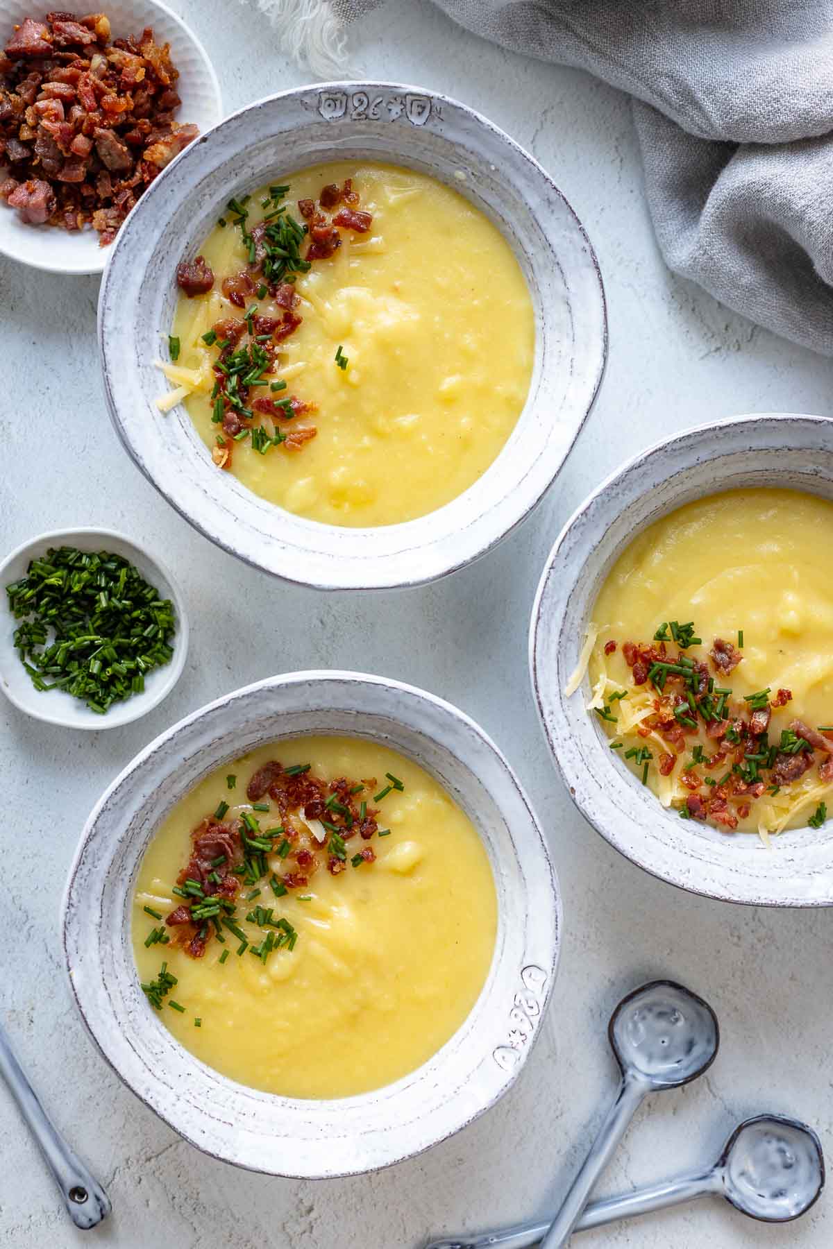 Kartoffel-Käse-Suppe Rezept mit Cheddar, Speck und Schnittlauch serviert in Schüsseln