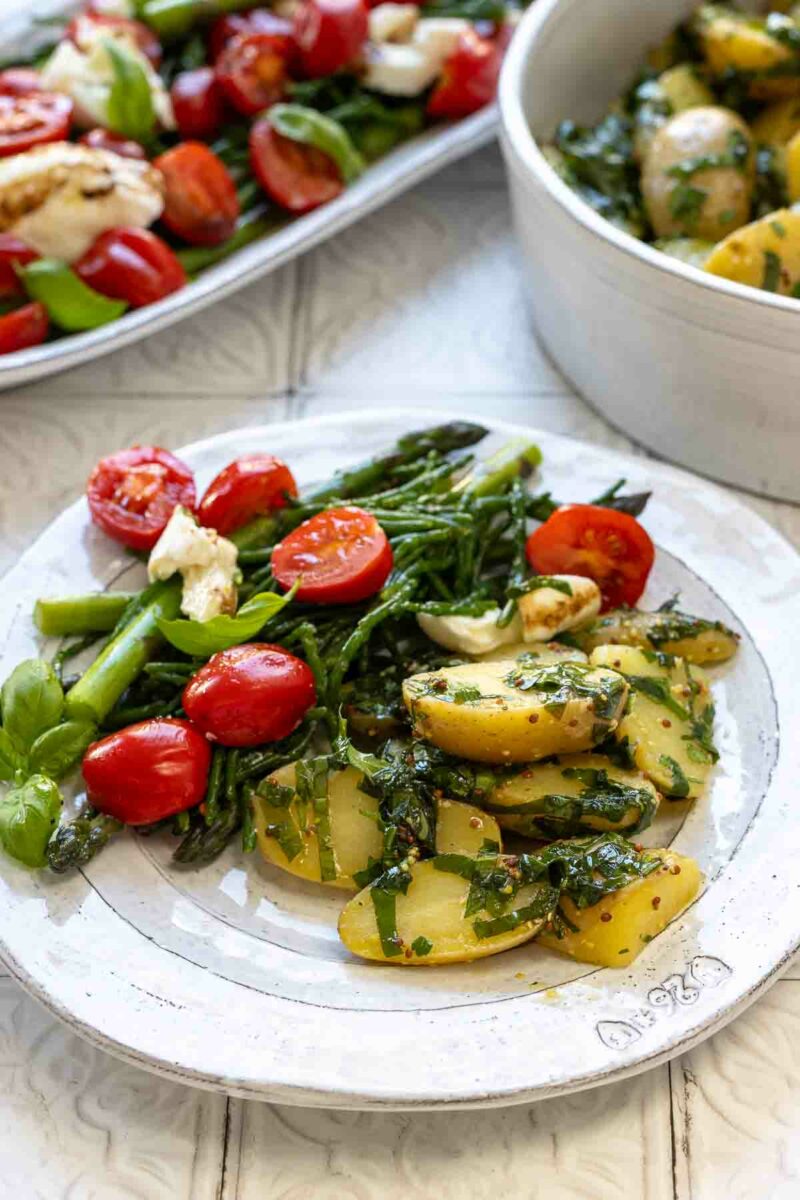 Bärlauch-Kartoffelsalat und Caprese-Salat mit grünem Spargel und Meeresspargel Serviert