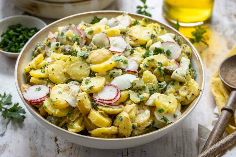 Kartoffelsalat mit Mayonnaise, Ei und Gurke Rezept dazu Schnittlauch und Radieschen